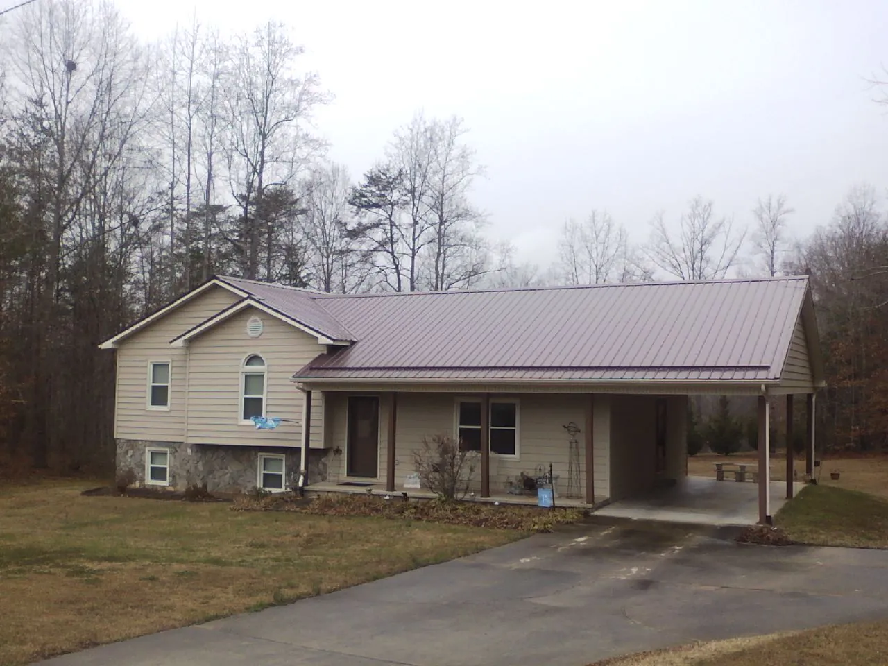 Burgundy metal roof on a tan split level home with an attached carport in Golden Valley