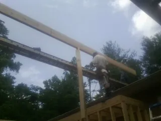 Carpenter setting a ridge beam over a new addition frame — Ice Dam Removal by Roofing Brothers in Golden Valley