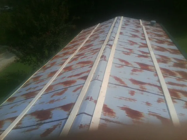 Rusted metal roof panels with new wood purlins before replacement — Storm Damage Roof Repair in Golden Valley by Roofing Brothers