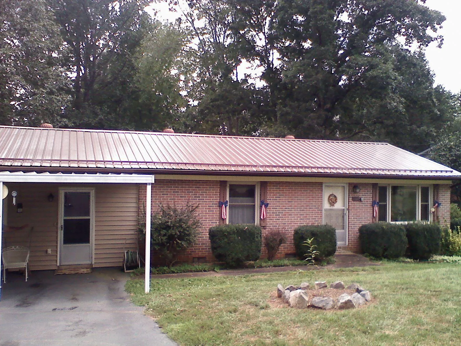 Bronze metal roof and carport on a brick ranch home — Roof Repair work by our crew in Golden Valley